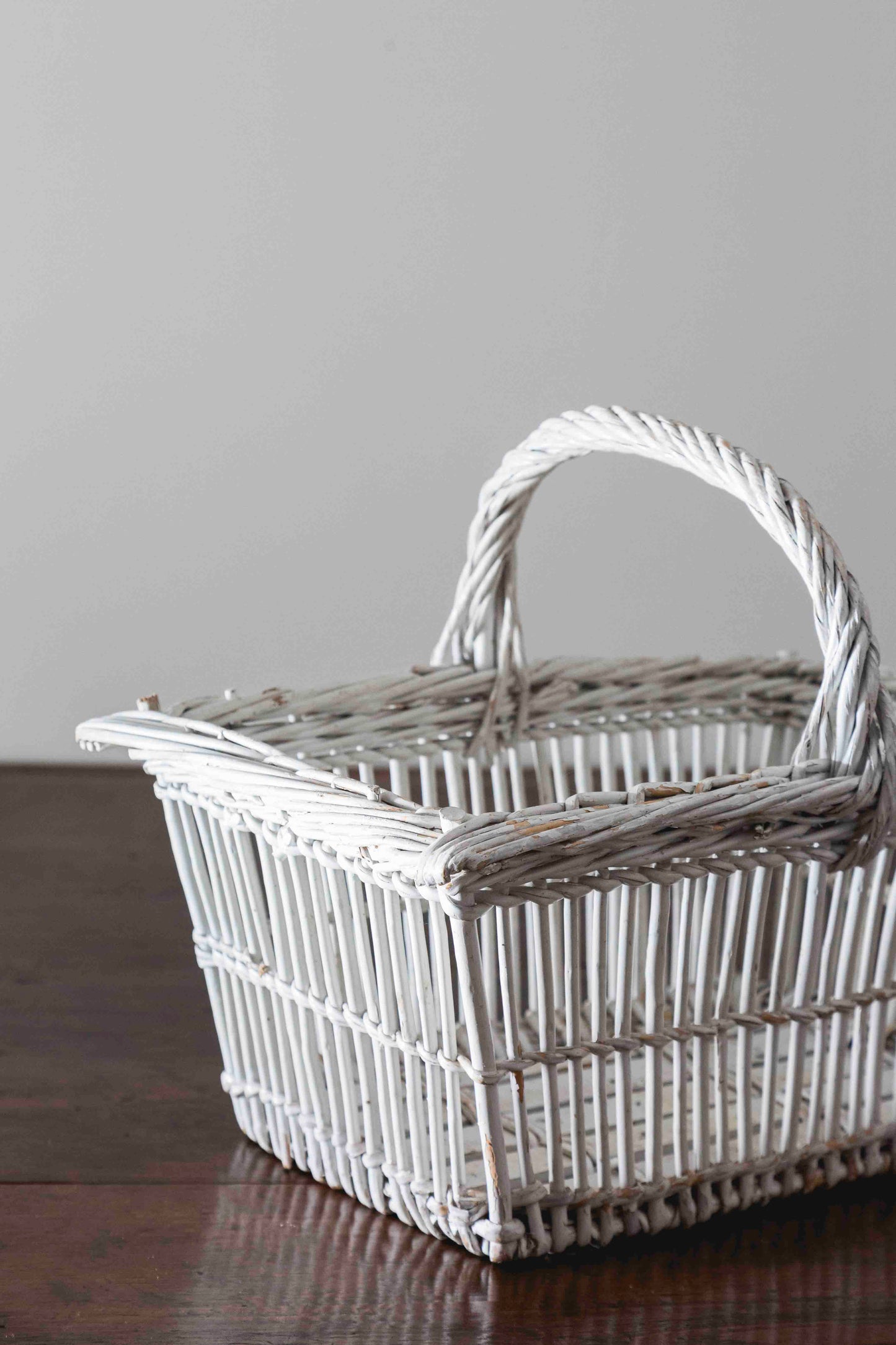 Cesta blanca antigua de mimbre con asa