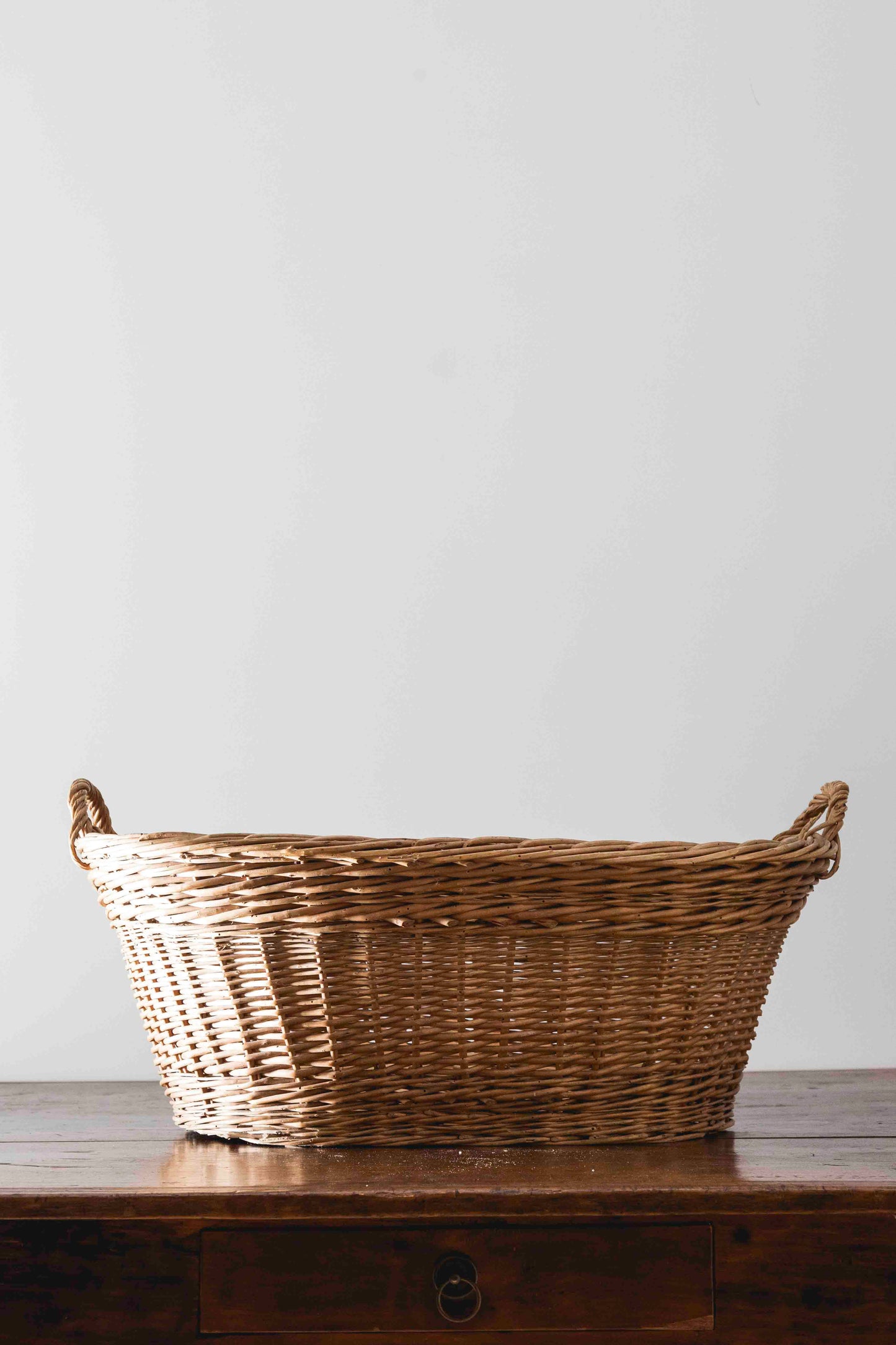 Cesta ovalada antigua de mimbre con asas